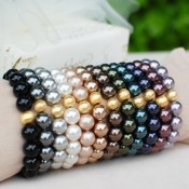Pearl Stretch Bracelets shown in (left to right) Mystic Black, Dark Gray, White, Powder Almond, Bronze, Brown, Dark Green, Tahitian Look, Dark Purple, Burgundy, Mauve.
